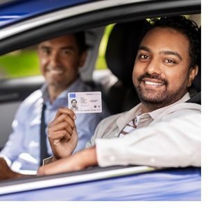 man in car holding drivers license